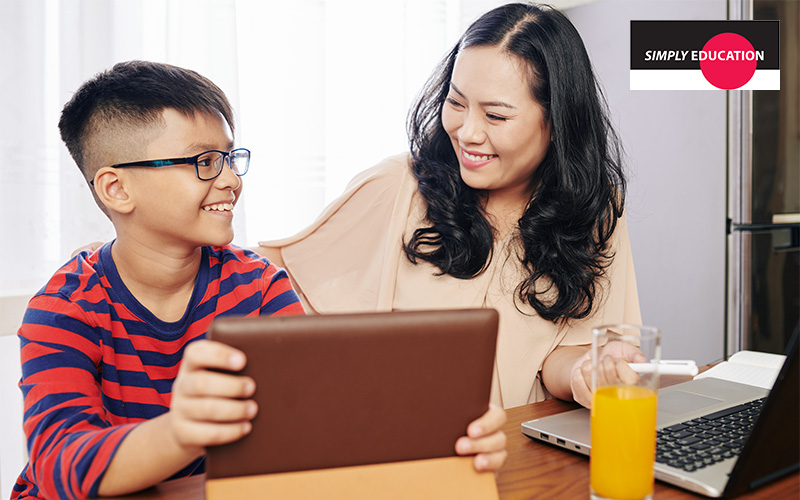 A mother and son studying together using a tablet.