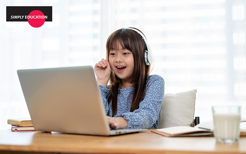 A student with headphones engaged in an online lesson.