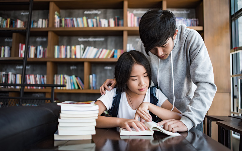 Two students studying together in a library